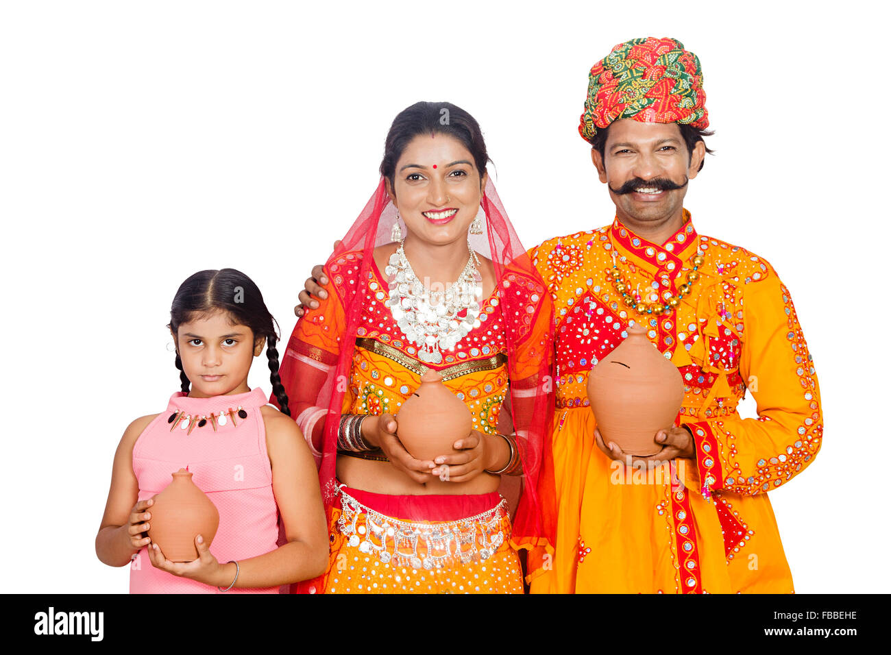 3 indian rural Gujrati Parents and kid doughter Piggy Bank saving money Stock Photo