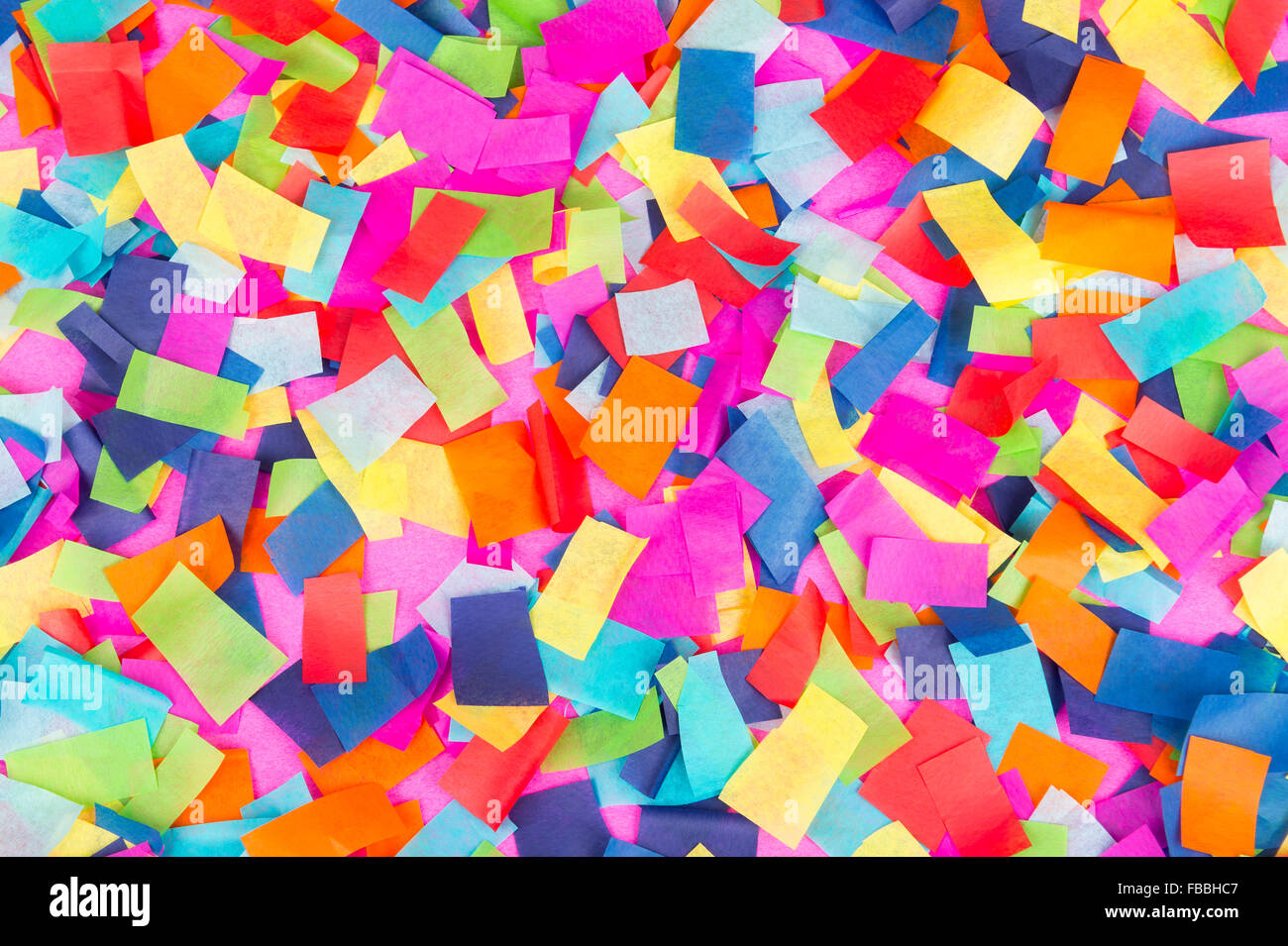 Brightly colored paper confetti background featuring red, yellow, blue,  green, orange, and bright pink carnival colors Stock Photo