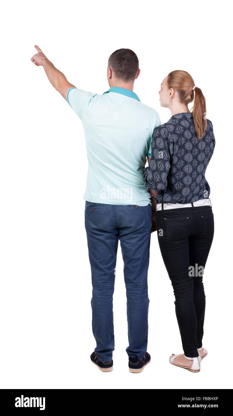 young couple pointing at wal Back view (woman and man). Rear view ...