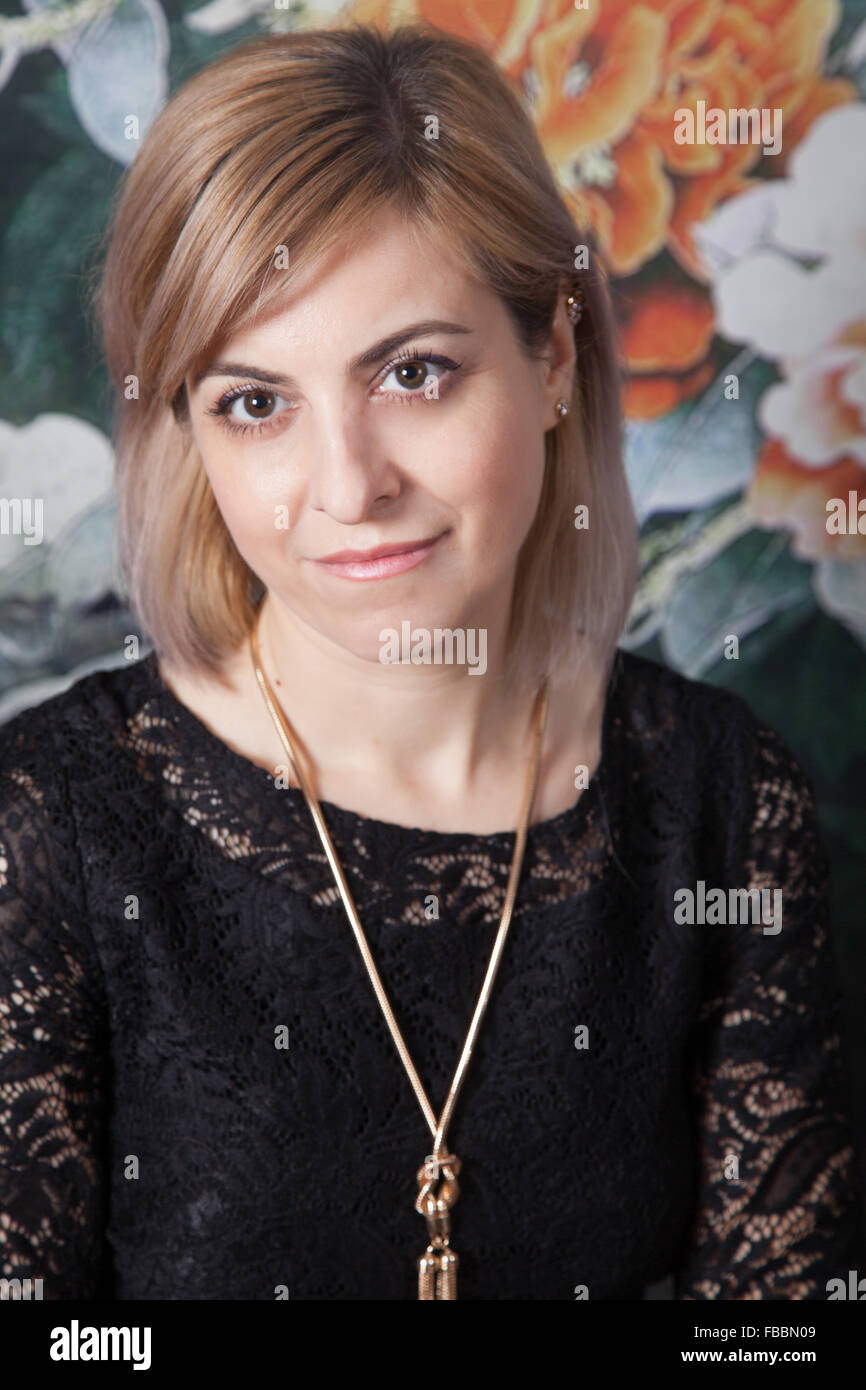 Beautiful woman portrait, studio shot, over floral background. Stock Photo