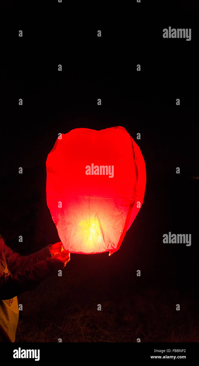 Releasing a Chinese lantern into the dark Stock Photo