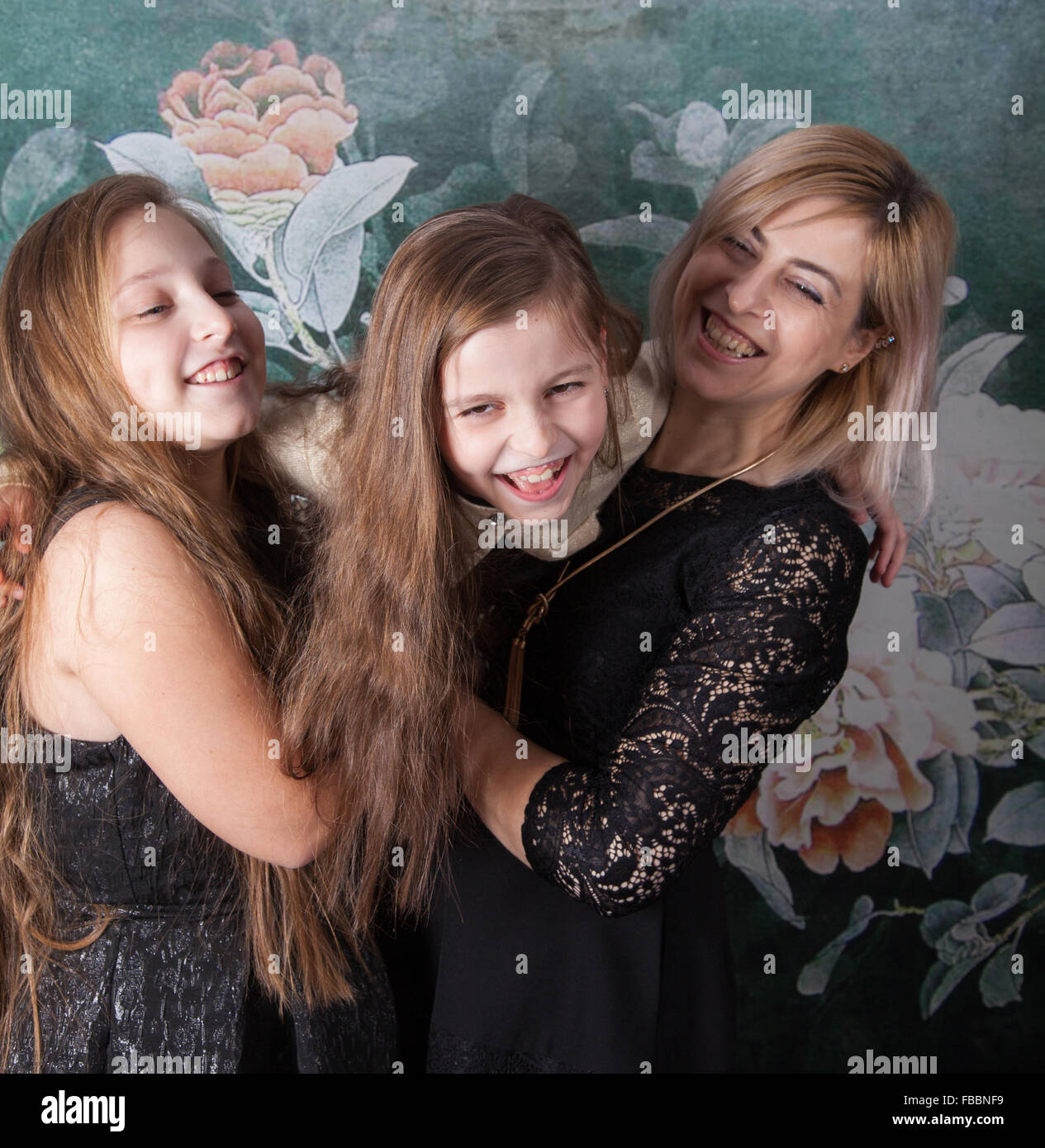 Portrait of a beautiful mother with her 2 daughters, studio shot. Stock Photo