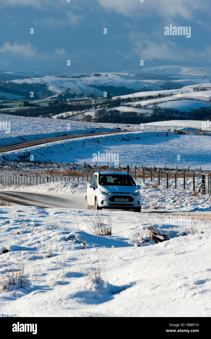Builth  Wells, Powys, Wales, UK. 14th January, 2016. UK weather. Motorists drive through a winter landscape on the'Brecon Road' between Builth Wells and Brecon.About 5cm of snow fell last night on the high moorland of the Mynydd Epynt, near Builth Wells, Powys, Wales. Credit:  Graham M. Lawrence/Alamy Live News. Stock Photo