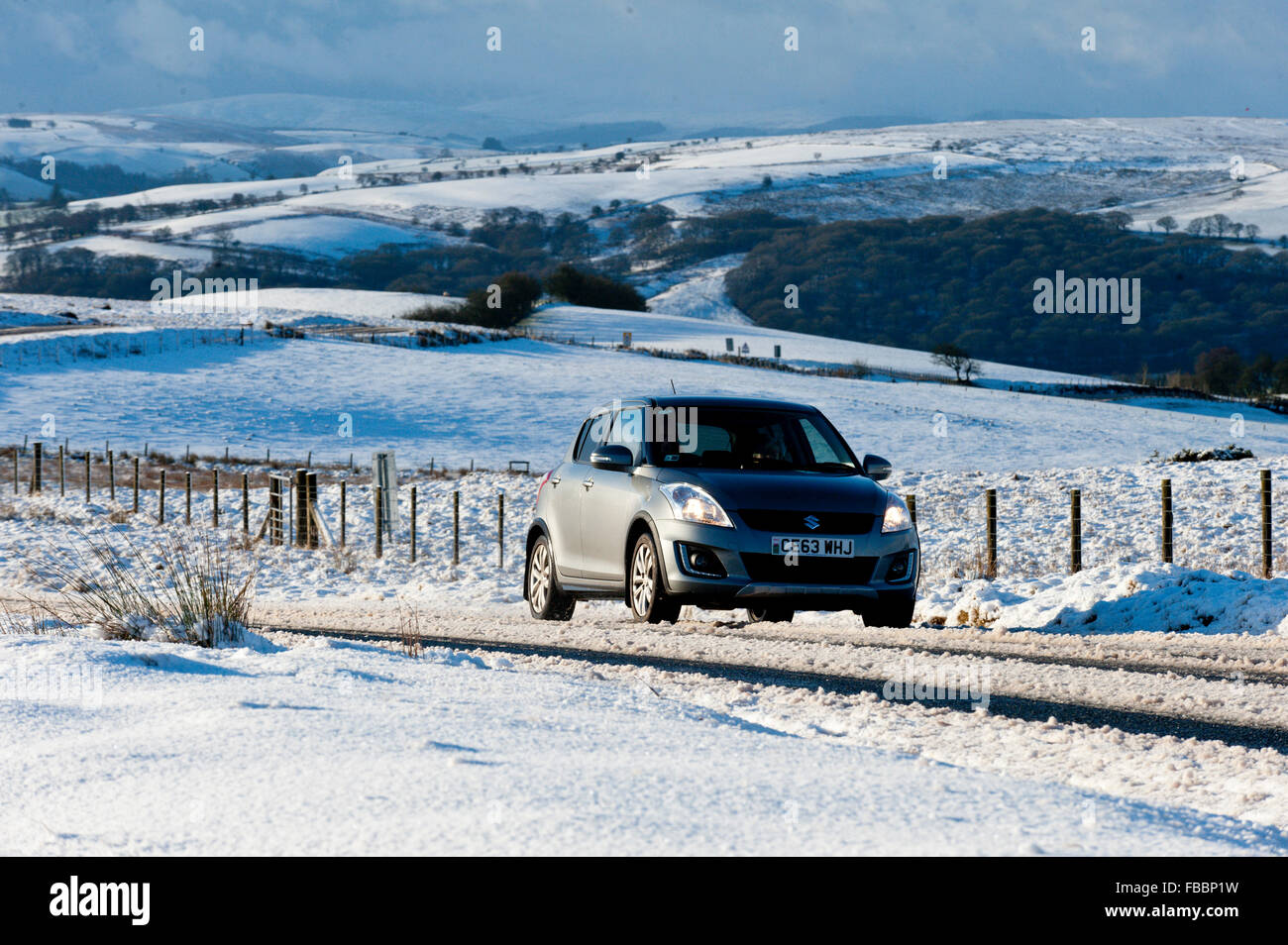 Builth  Wells, Powys, Wales, UK. 14th January, 2016. UK weather. Motorists drive through a winter landscape on the'Brecon Road' between Builth Wells and Brecon.About 5cm of snow fell last night on the high moorland of the Mynydd Epynt, near Builth Wells, Powys, Wales. Credit:  Graham M. Lawrence/Alamy Live News. Stock Photo