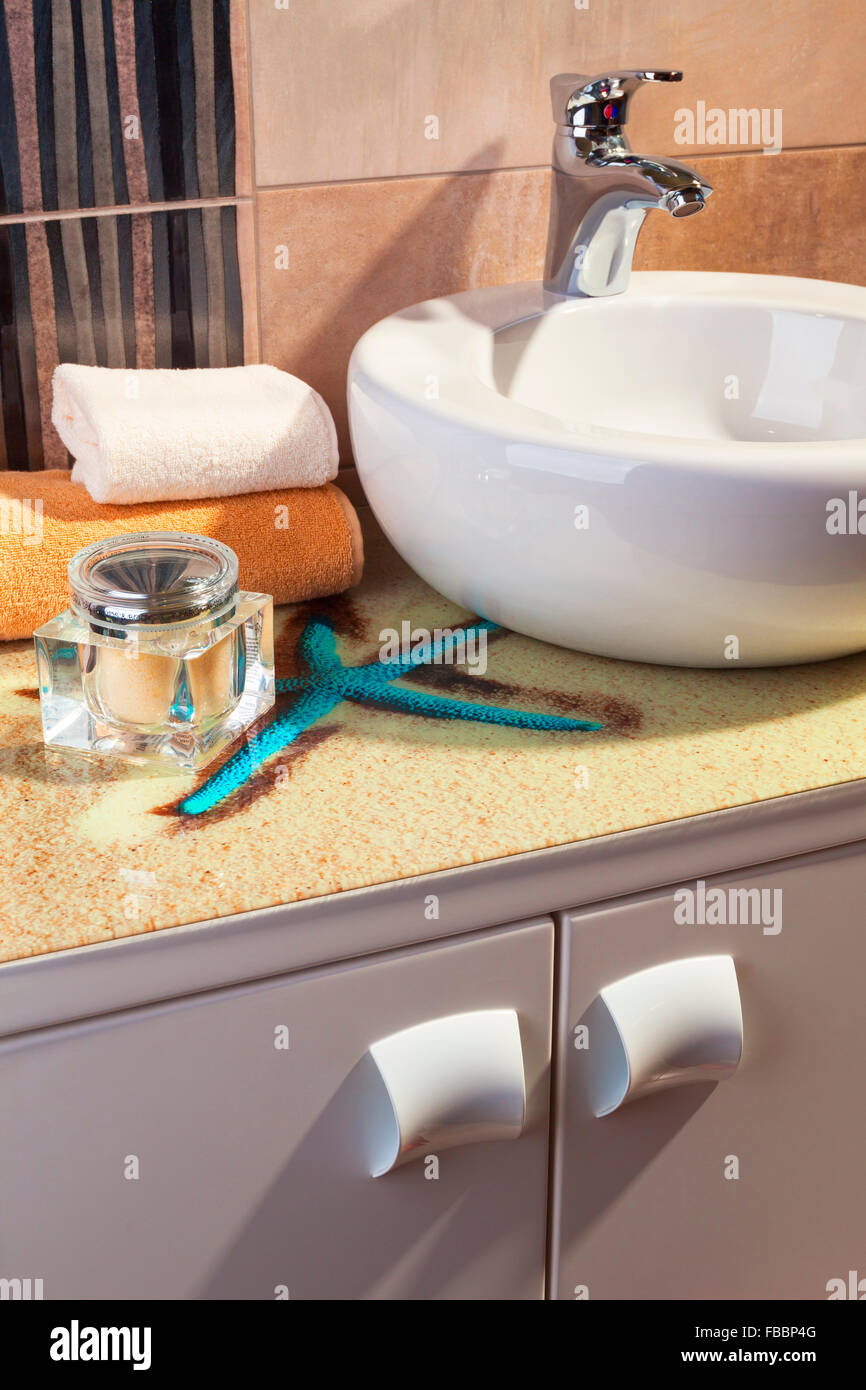 detail of modern bathroom in orange color with round white sink Stock