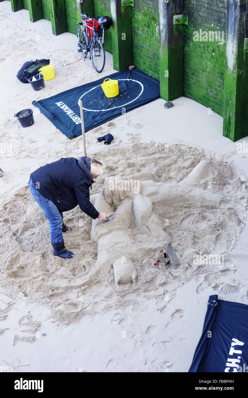 England, London, Southwark. A sculptor finishes a sand sculpture on the banks of the river Thames near Gabriel's Wharf. Stock Photo