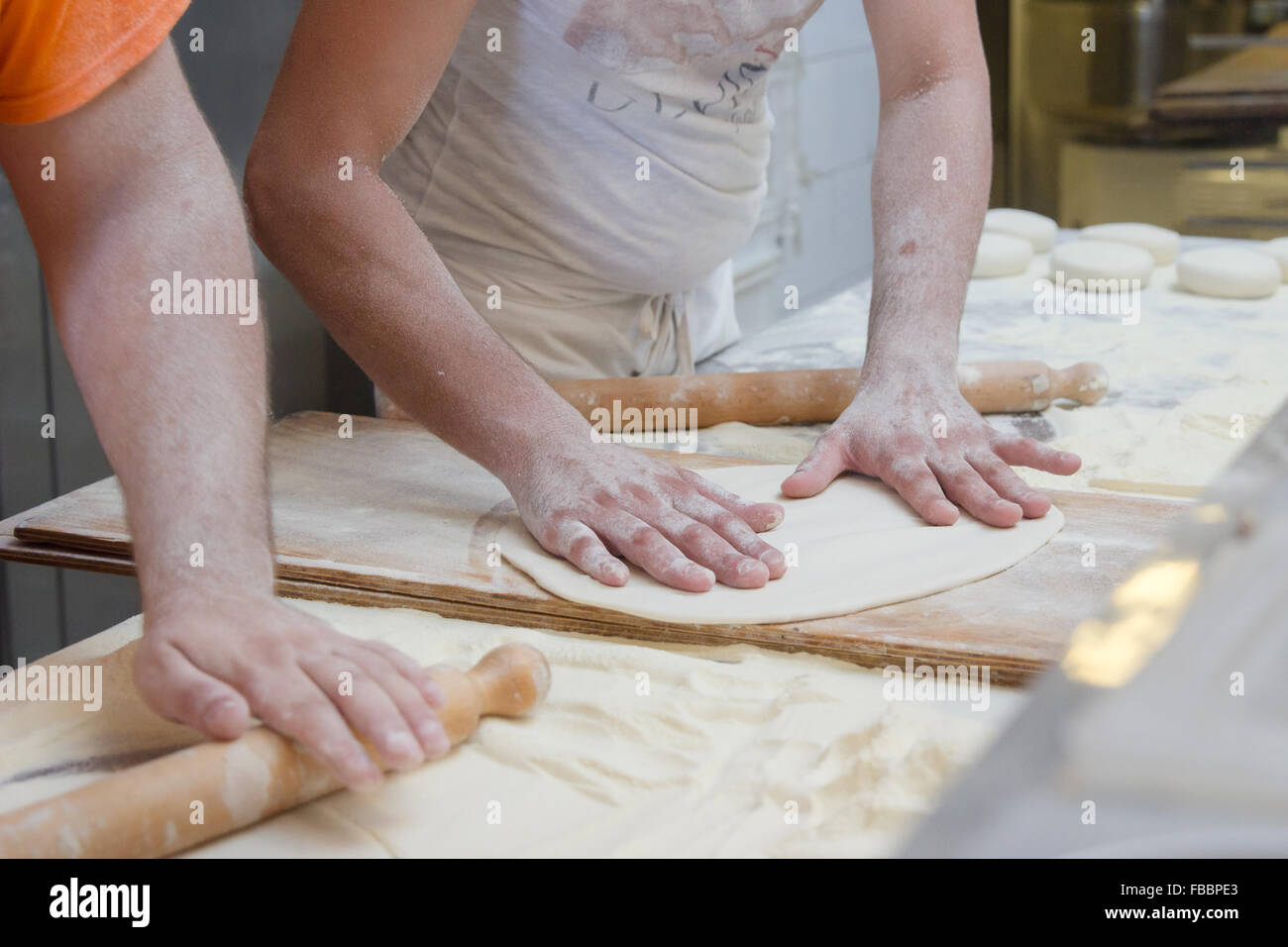 dough flour rolling-pin cooking men people table kitchen pizzeria Stock Photo