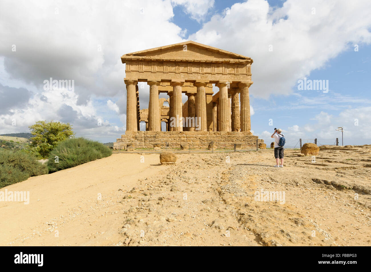 A tourist photographs the temple of Concordia, Valley of Temples, Agricento, Sicily, Italy Stock Photo