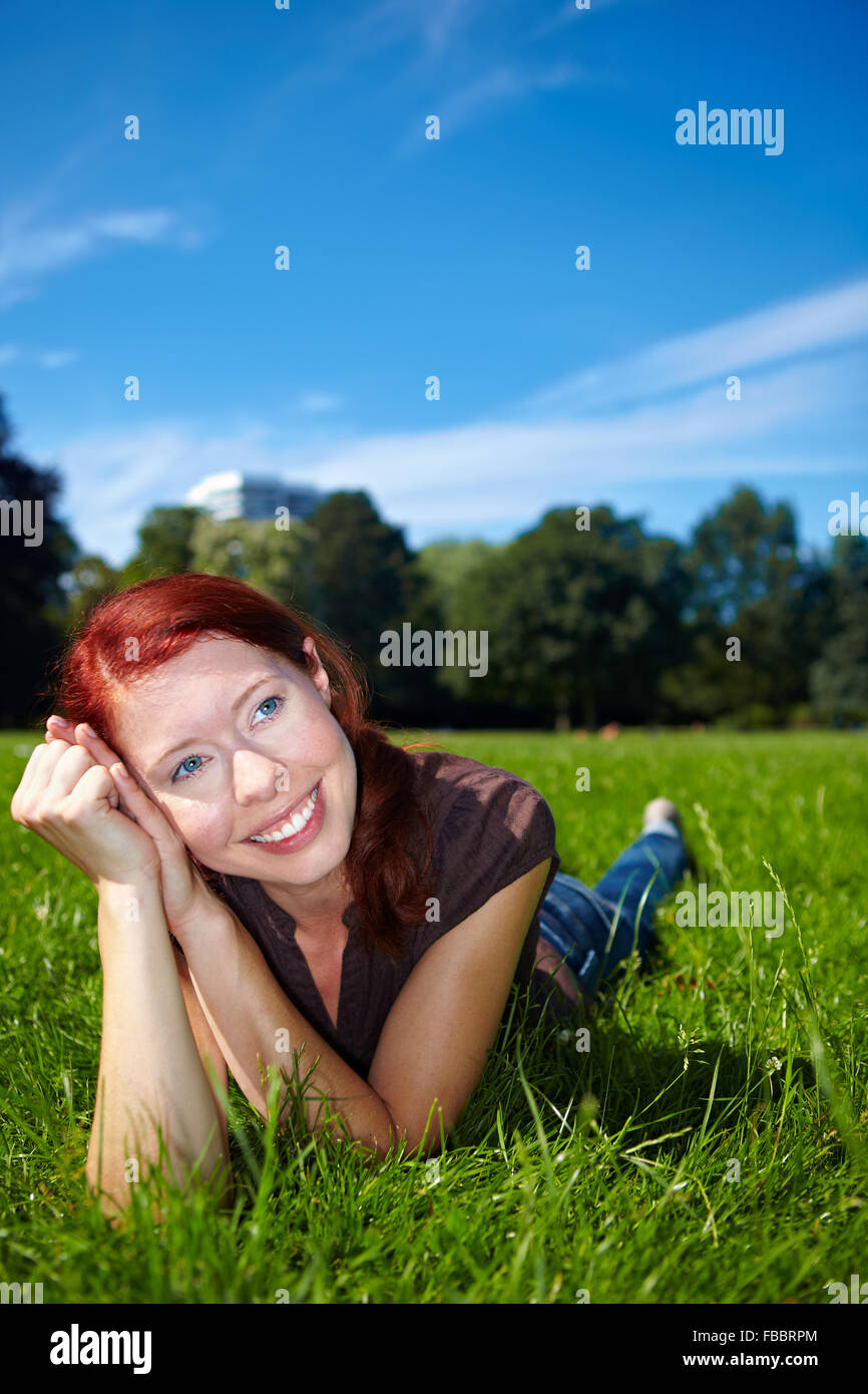 Smiling woman daydreaming in nature on a meadow Stock Photo