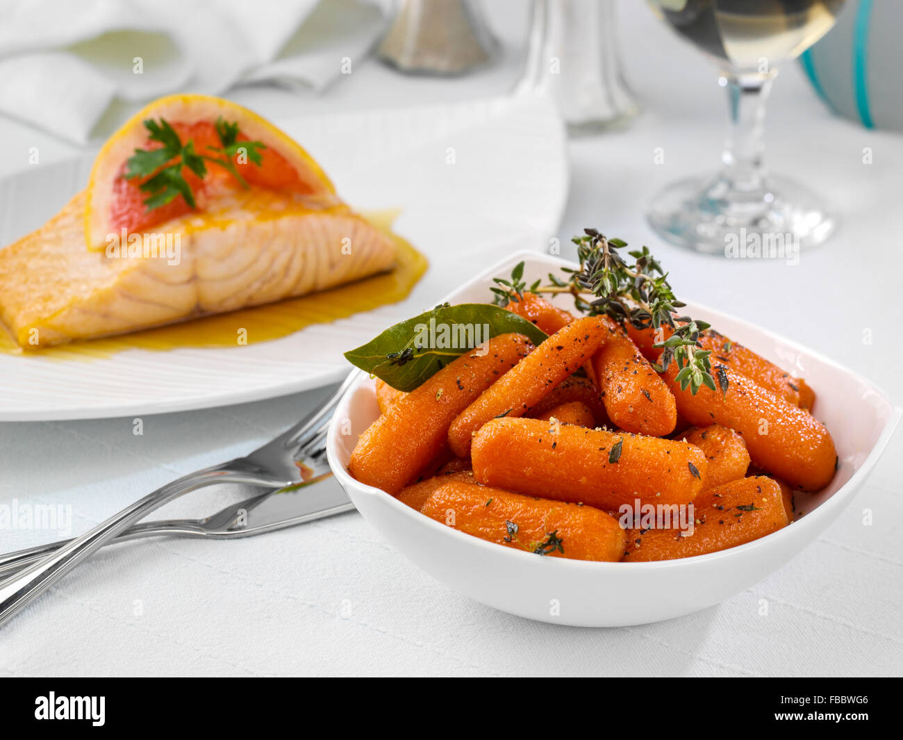 Glazed carrots with seared salmon behind Stock Photo Alamy