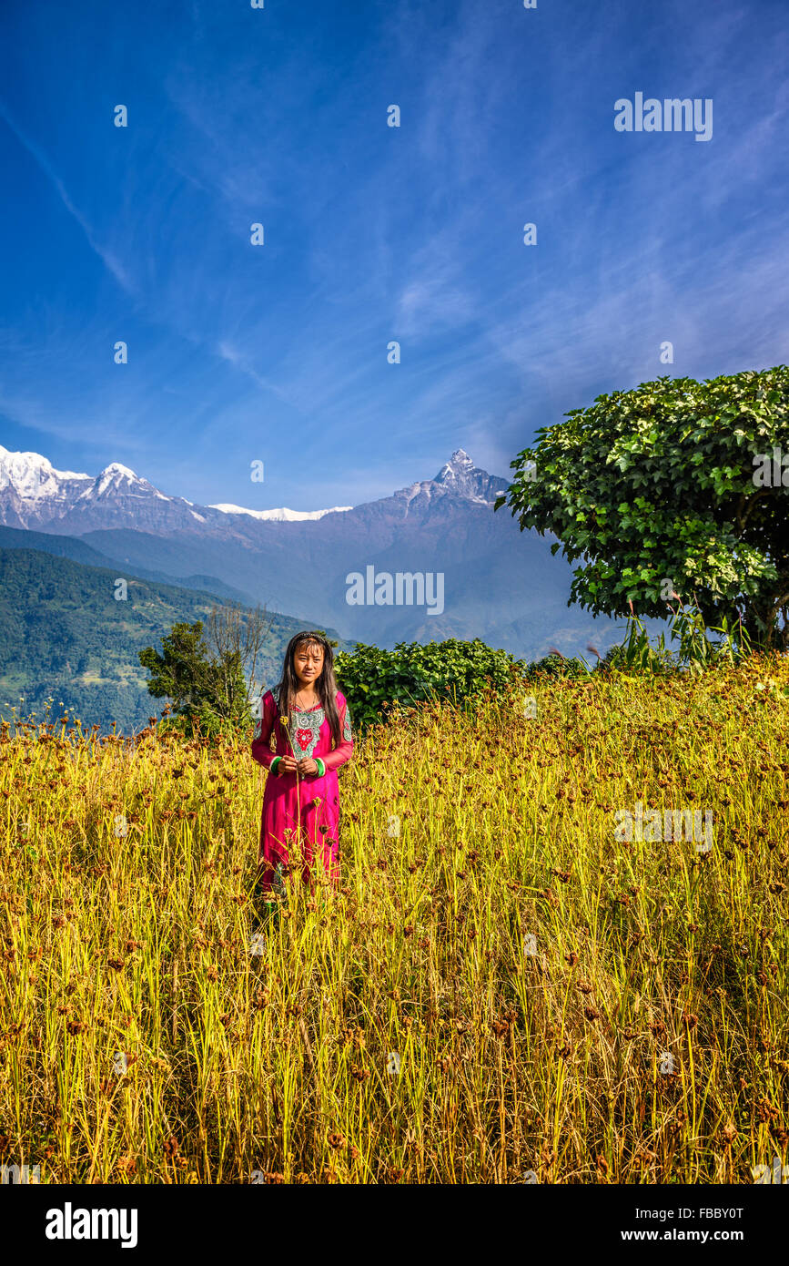 Young girl plays on a field in the Himalayas mountains near Pokhara Stock Photo