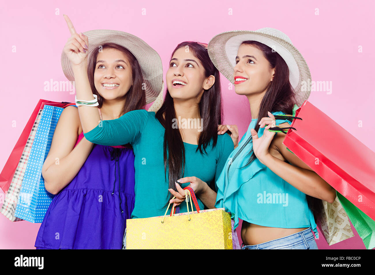 3 indian Young Womans friends shopping finger pointing showing Stock Photo