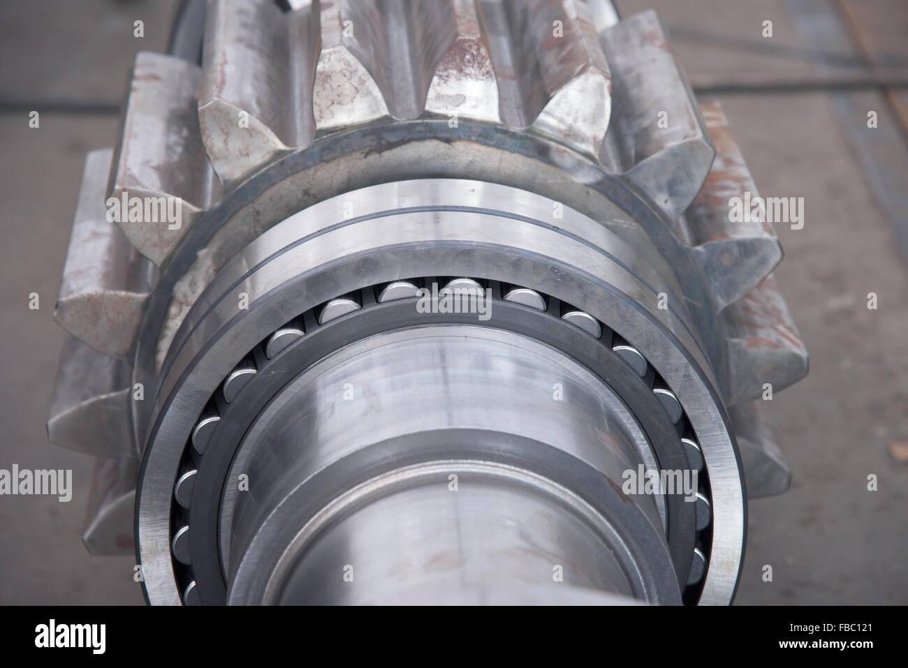 Stainless roller bearing on industrial size drive shaft. Shallow depth of field with only parts