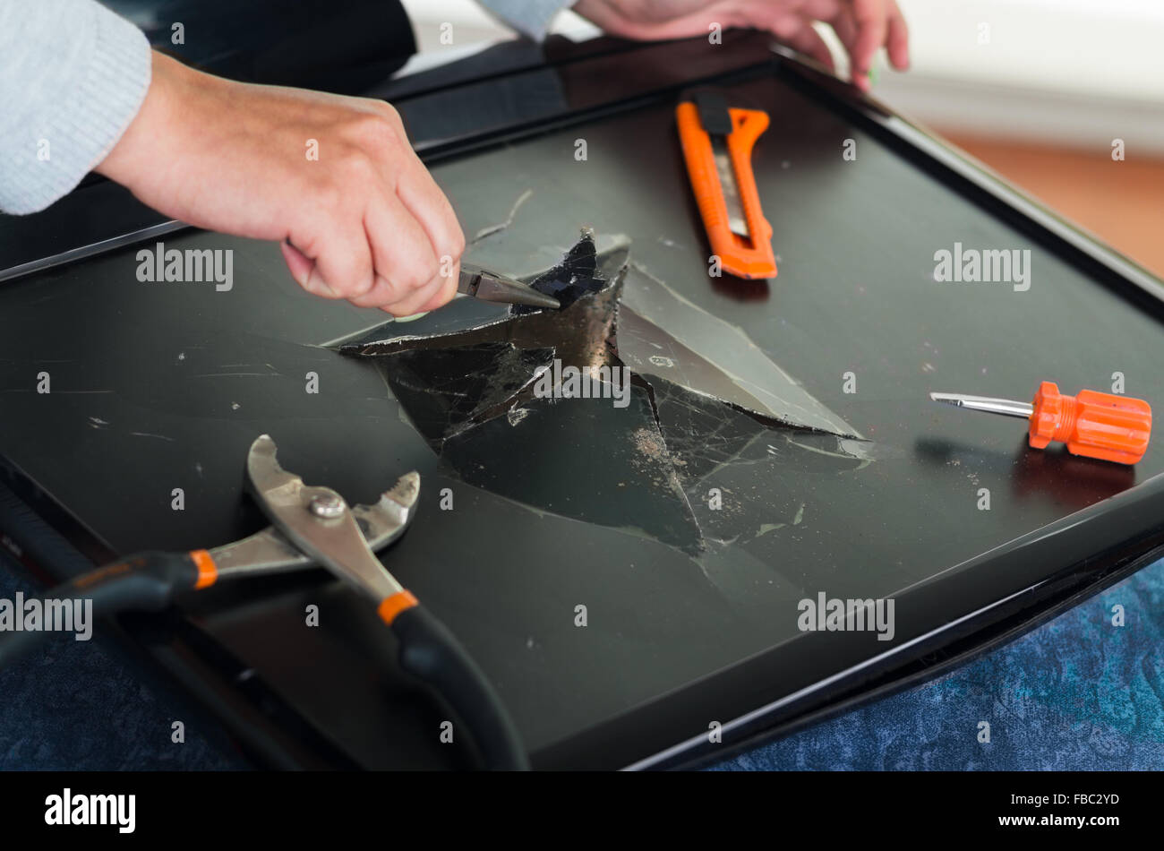 Hands working on broken computer screen using different tools Stock ...