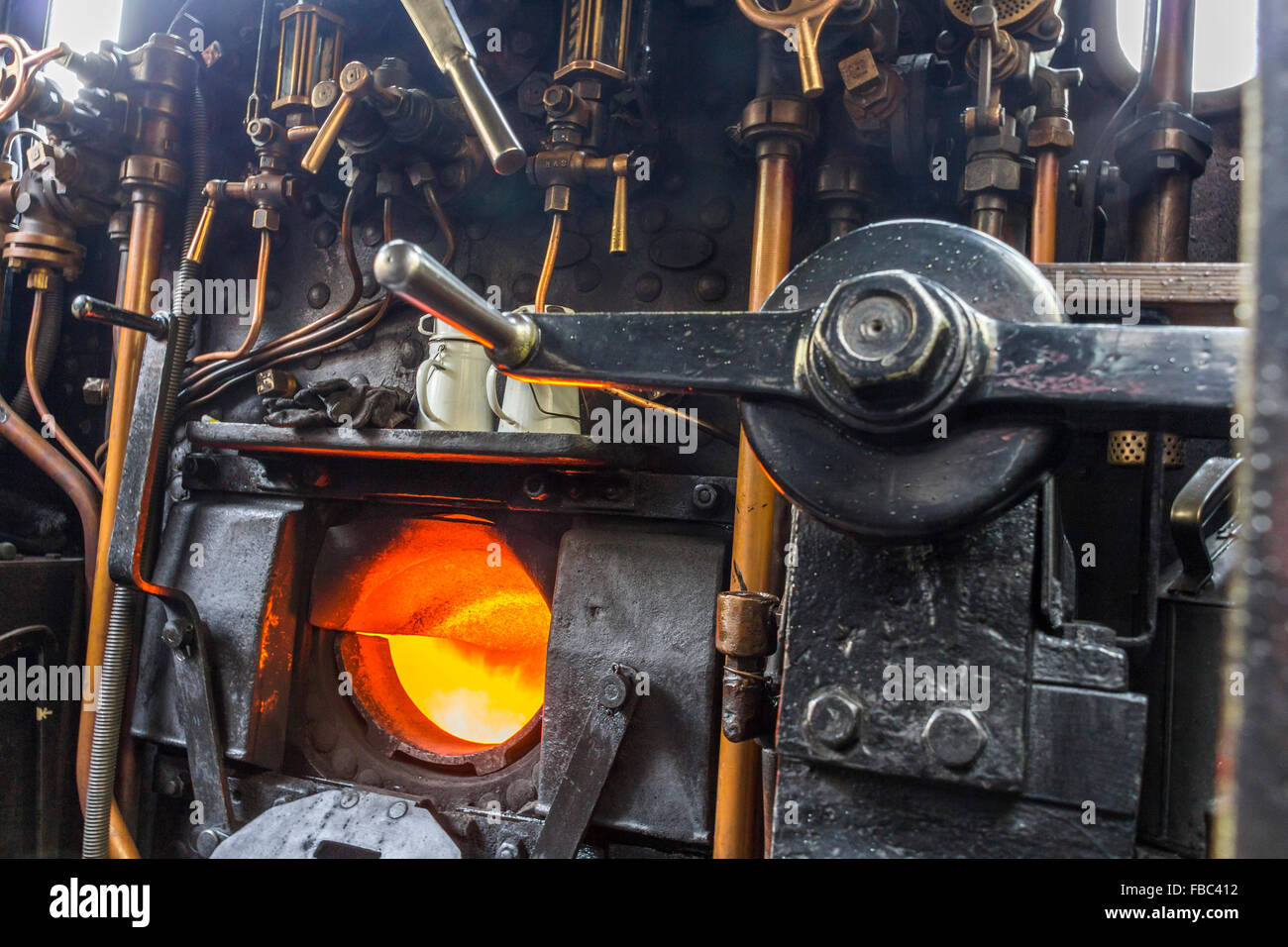 Fire box on a steam locomotive with controls and copper pipes Stock Photo