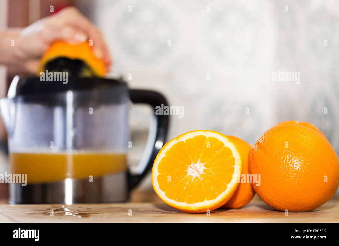 Squeezing orange to extract some healthy juice. Stock Photo