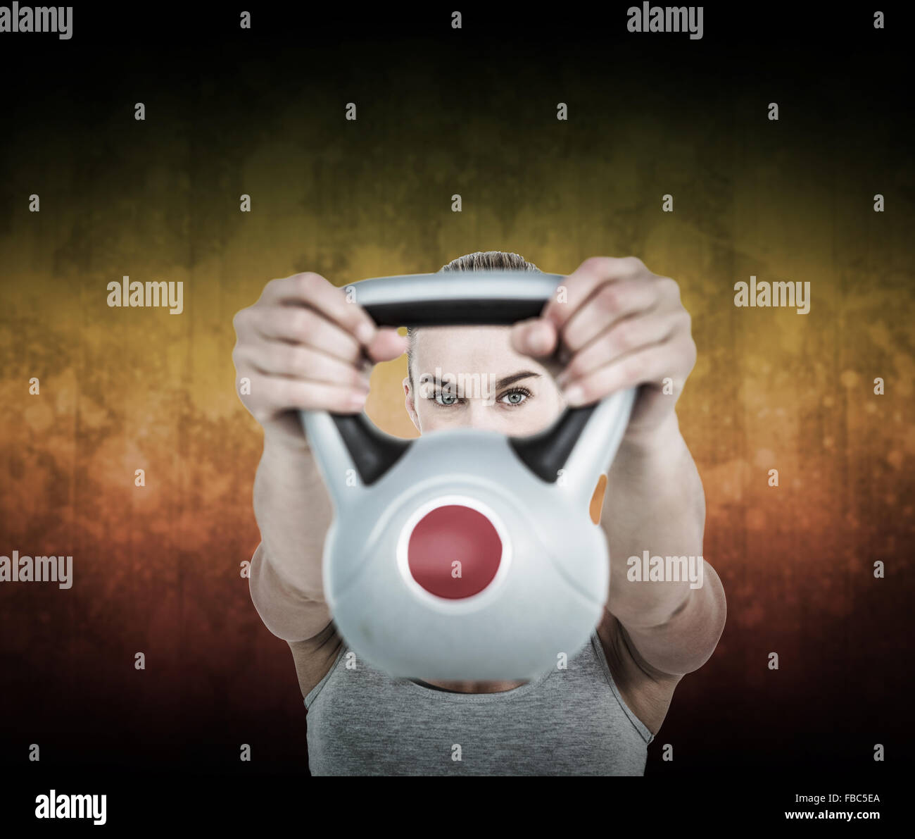 Composite image of serious muscular woman lifting kettlebell Stock Photo