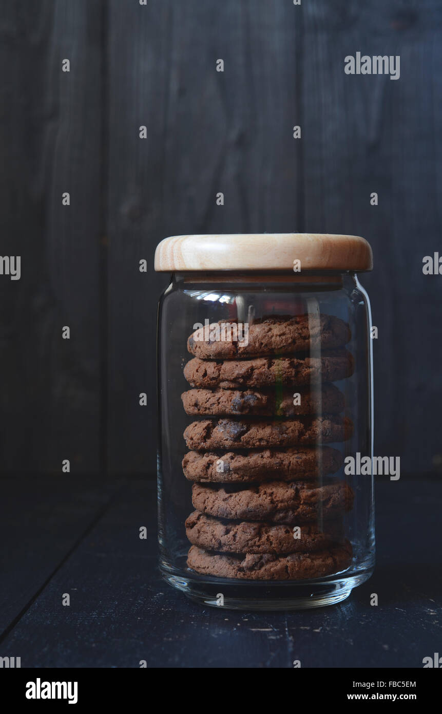 Chocolate chip cookies in a jar, against dark background Stock Photo