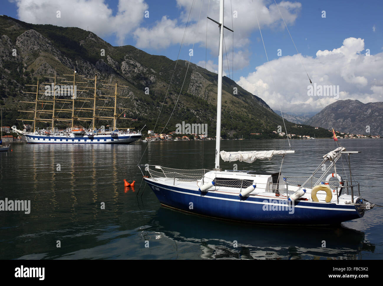 A tall ship pictured alongside a yacht in the Bay of Kotor near the medieval port town of Kotor in Montenegró Stock Photo