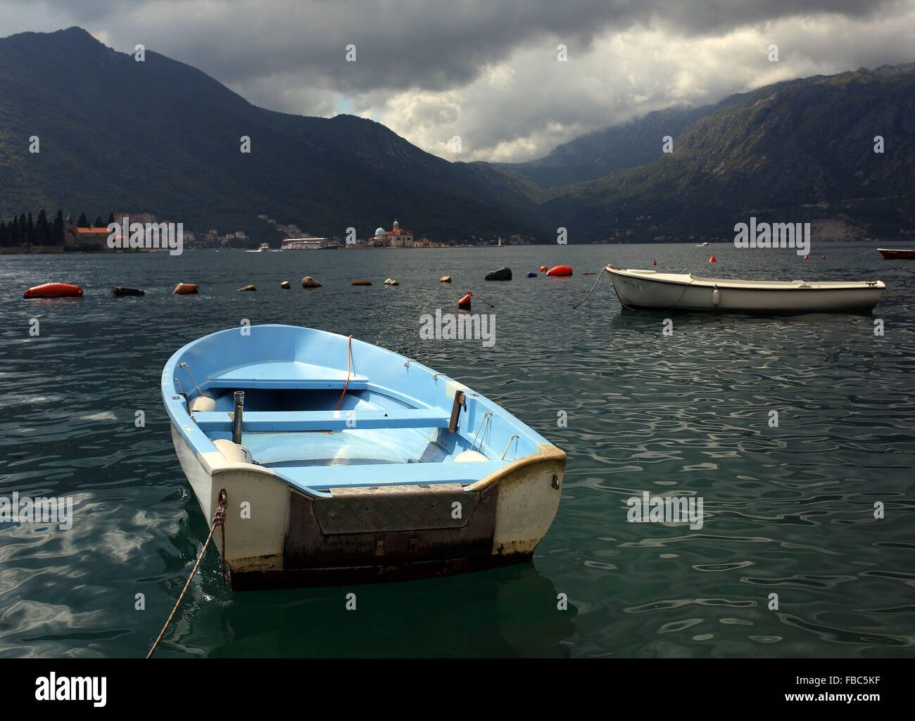 Dinghy boats are pictured moored in the Bay of Kotor in Montenegró near the old town of Perast. Stock Photo