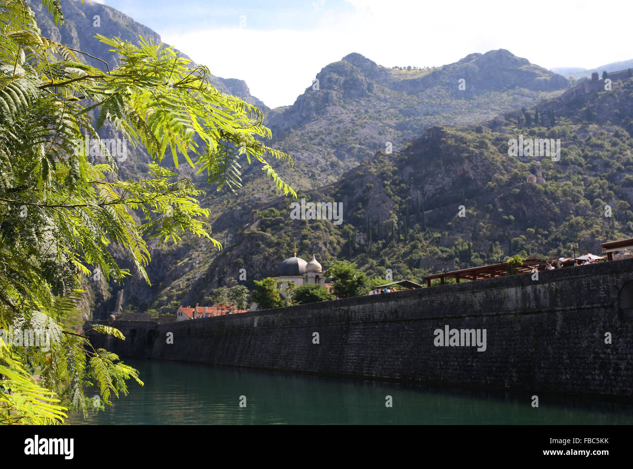 Mountains pictured looming over the city walls of the medieval port town of Kotor Montenegró Stock Photo