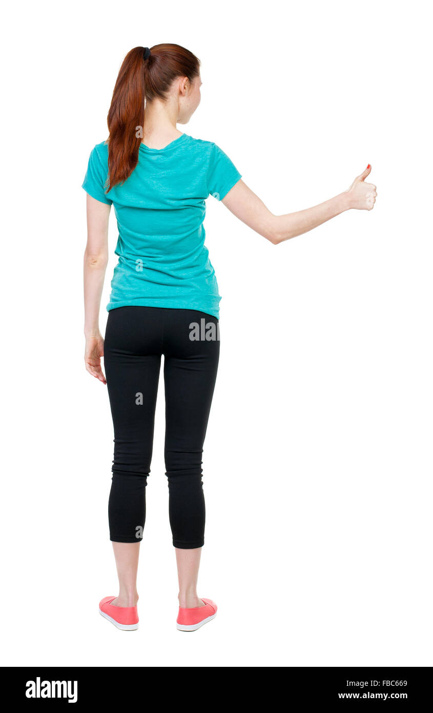 Back view of woman thumbs up. Rear view people collection. backside view of person. Isolated over white background. slender blonde in a jeans shows the symbol of success or hitchhiking Stock Photo