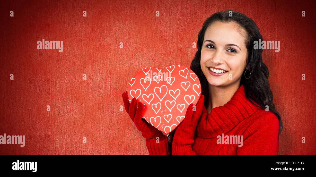 Composite image of smiling woman holding gift box Stock Photo