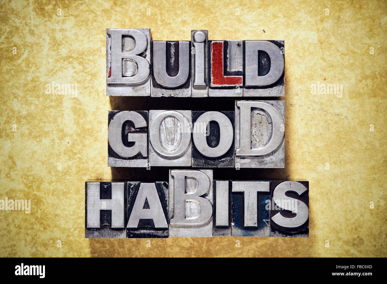 build good habits phrase made from metallic letterpress type on grunge cardboard background Stock Photo