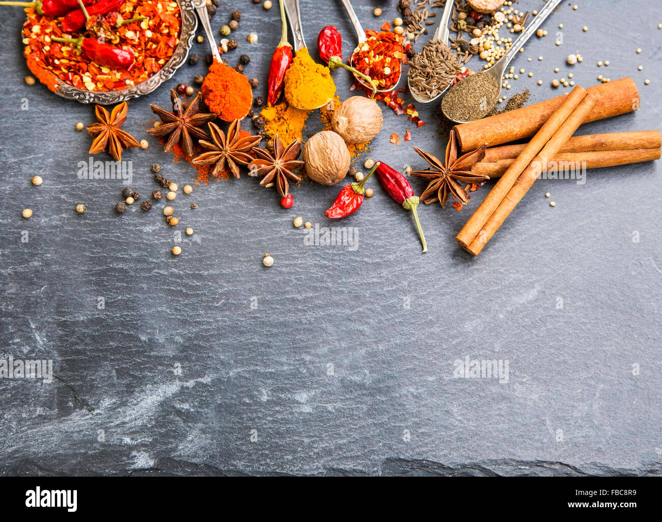 Aromatic spices with pepper and turmeric powders,cumin and coriander seeds, chili flakes , anise, nutmeg and cinnamon Stock Photo