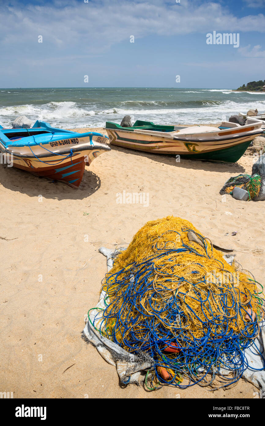Beach seine fishermen sort fish into baskets on Uppuveli beach on