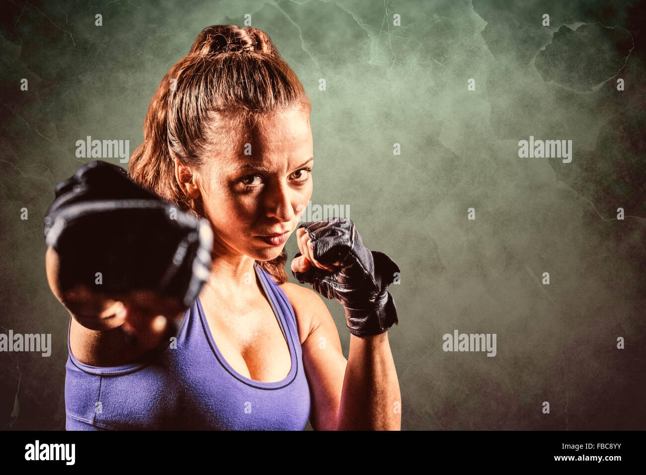 Composite image of portrait of female fighter punching Stock Photo