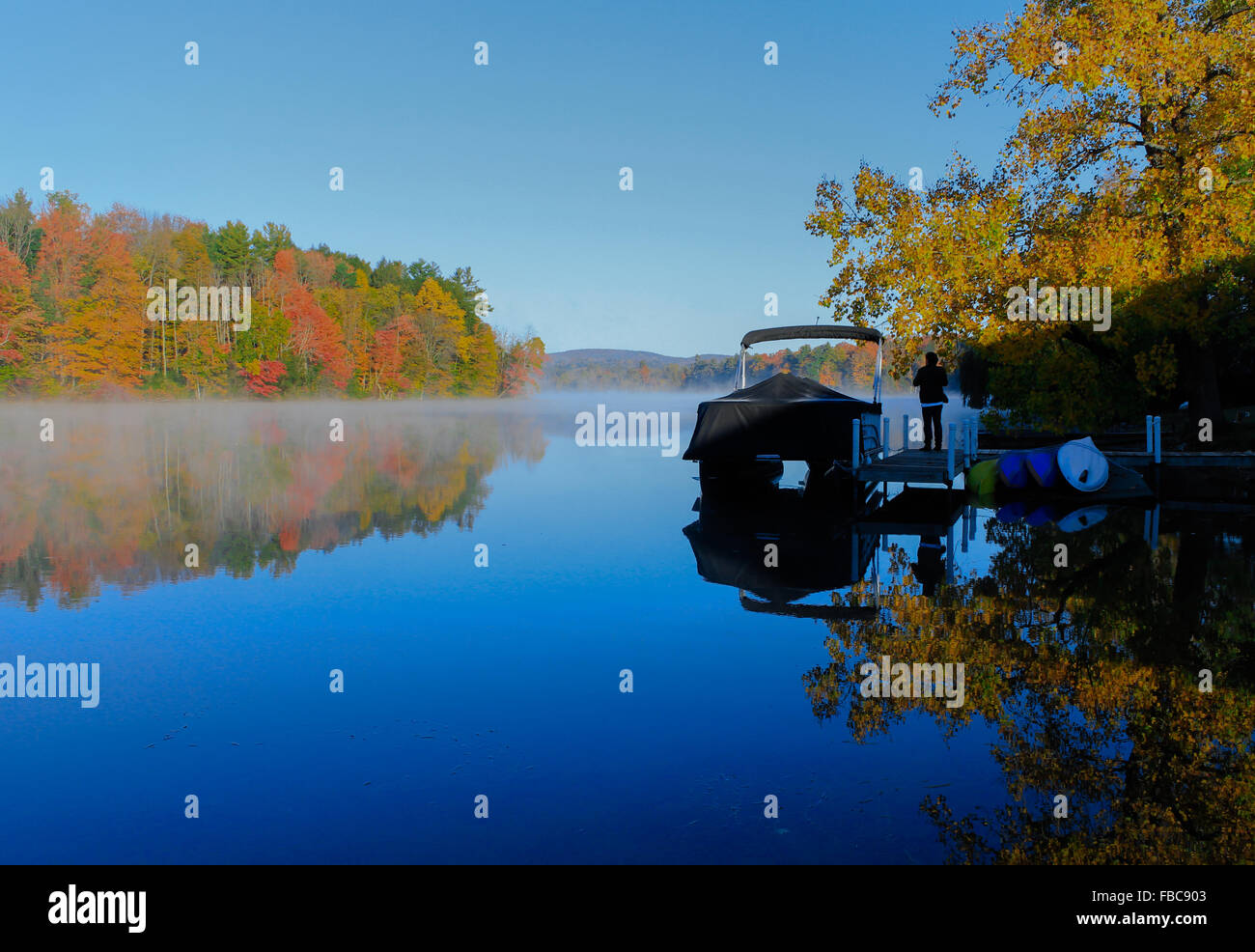 Colorful leaves reflected on Lake Laurel. Photographed in Lee, MA in Oct 2014. Stock Photo