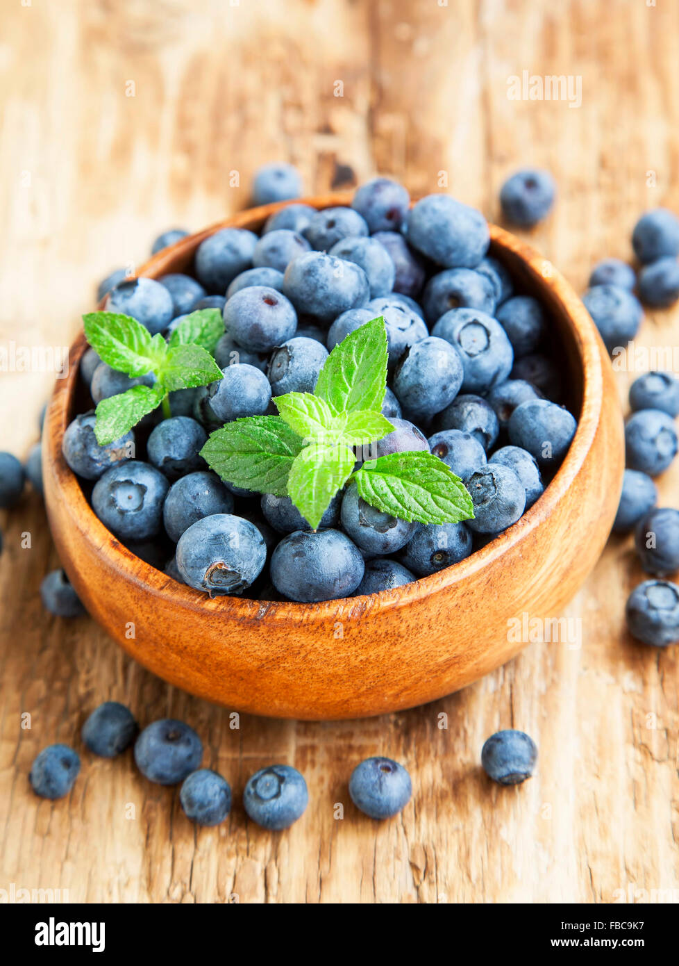 Blueberries Fruits in a Wooden Bowl with Mint Leaf Stock Photo