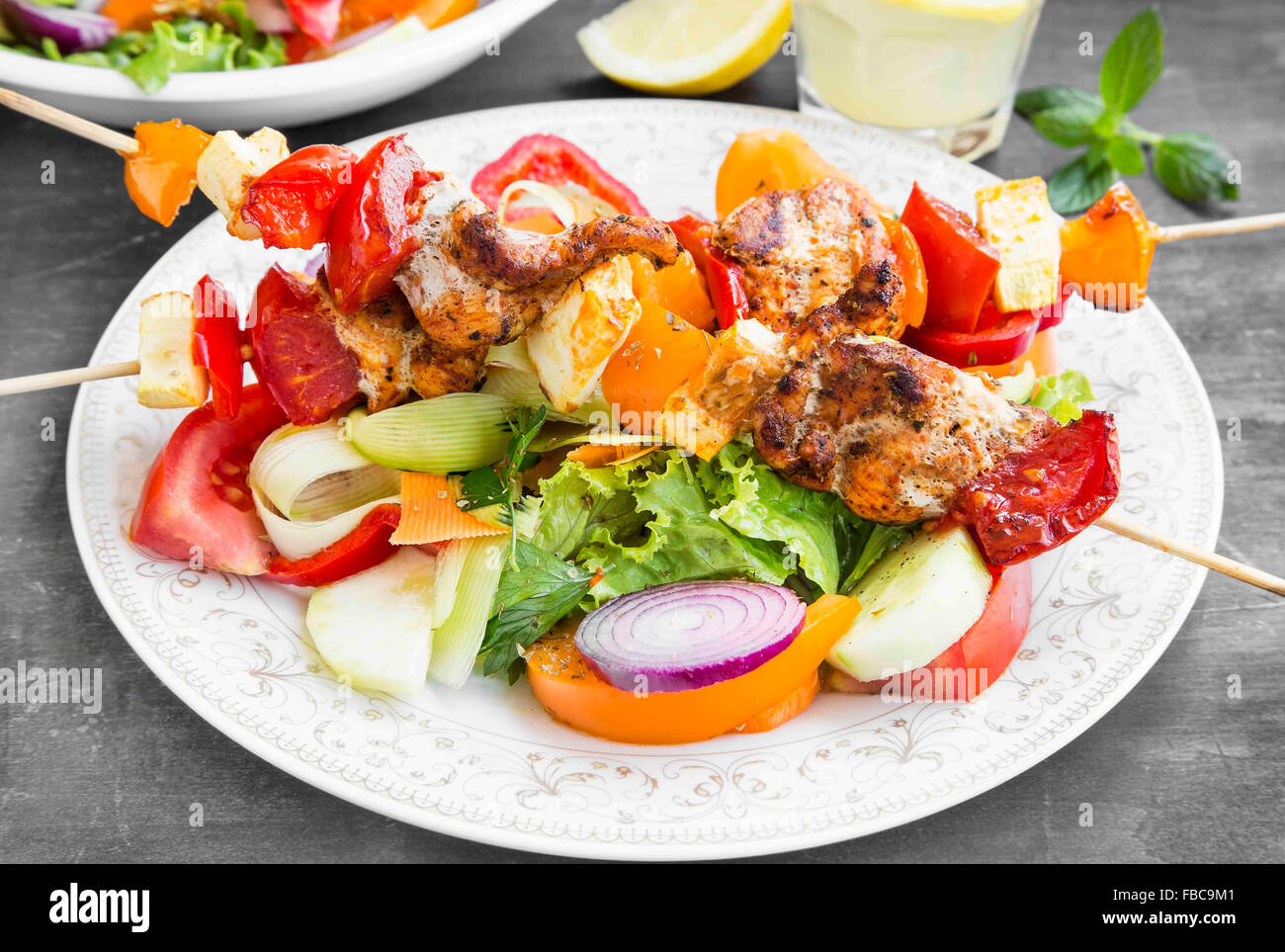 Skewers Meal with Grilled Chicken, Tomatoes, Peppers, Pumpkins and Vegetable Salads Stock Photo