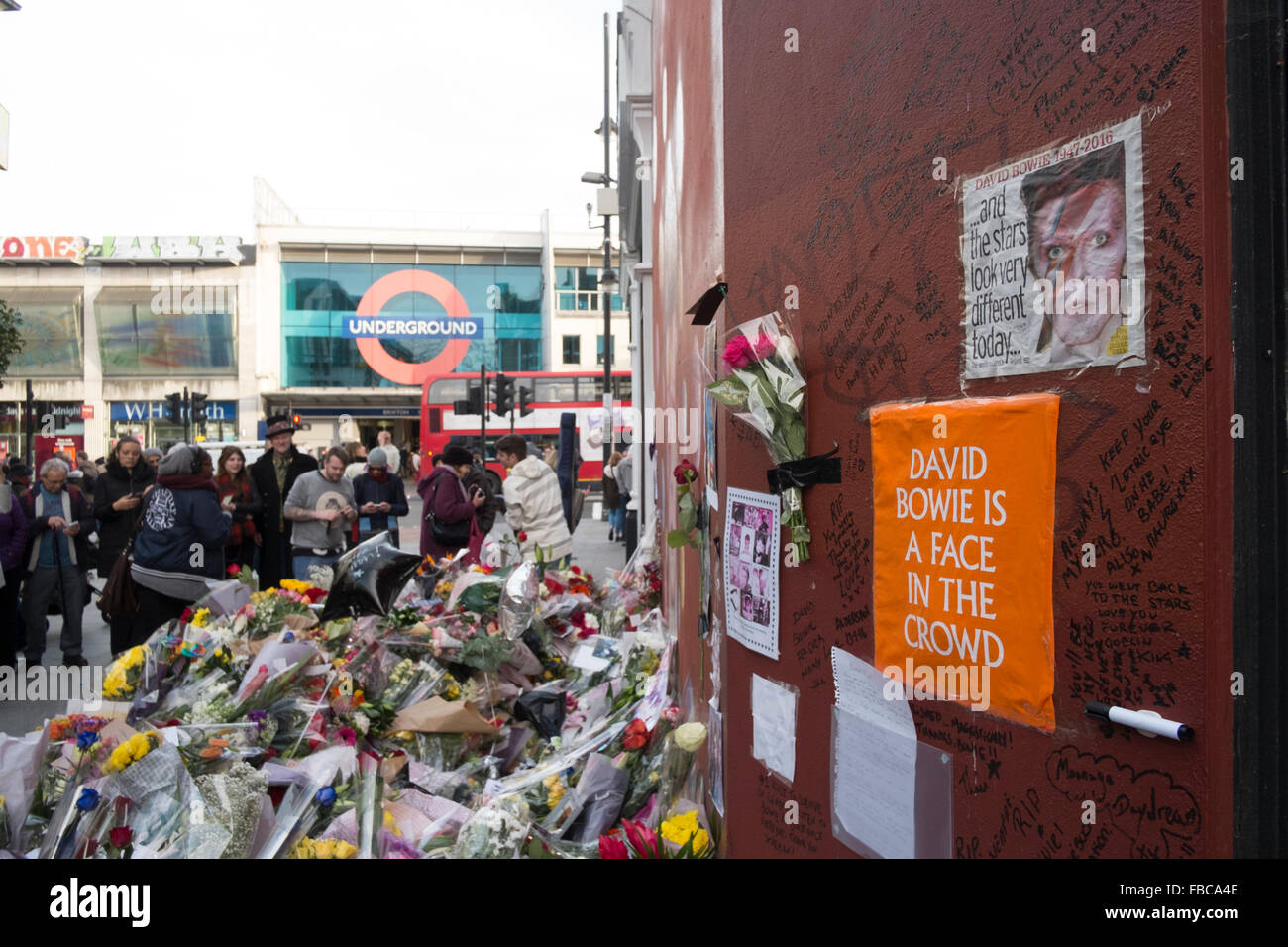 London, UK. 13th Jan, 2016.Fans pay tribute to David Bowie at a mural in Brixton where he was born. Stock Photo