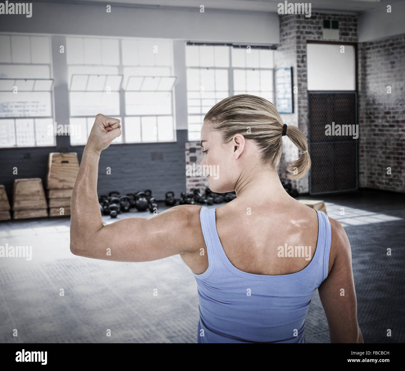 Composite image of rear view of muscular woman flexing muscles Stock ...