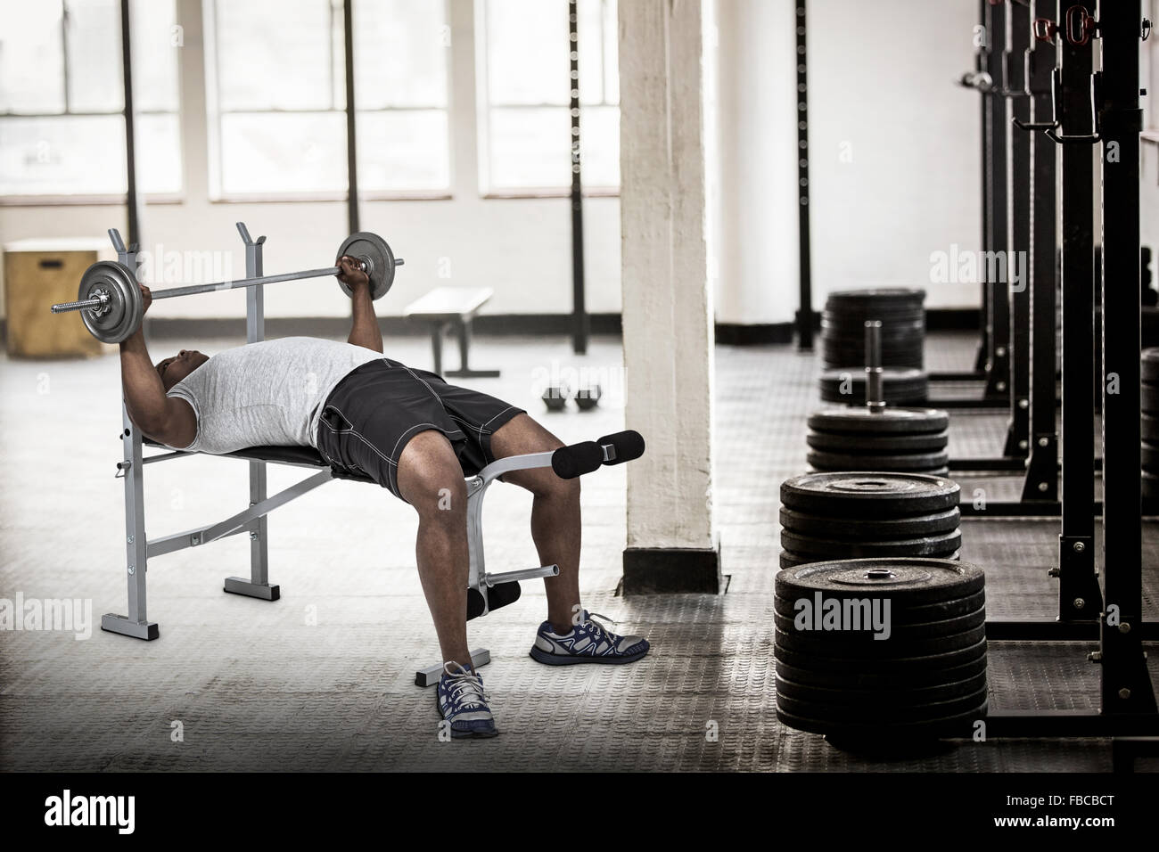 Composite image of fit man exercising with barbell Stock Photo