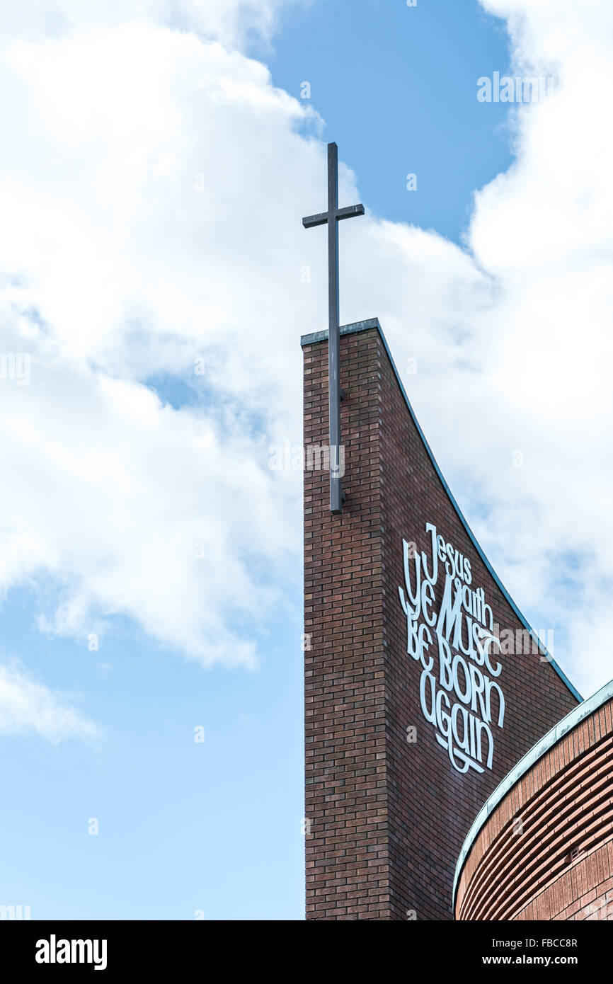 A church cross attached to side of Belfast church with religious message Stock Photo