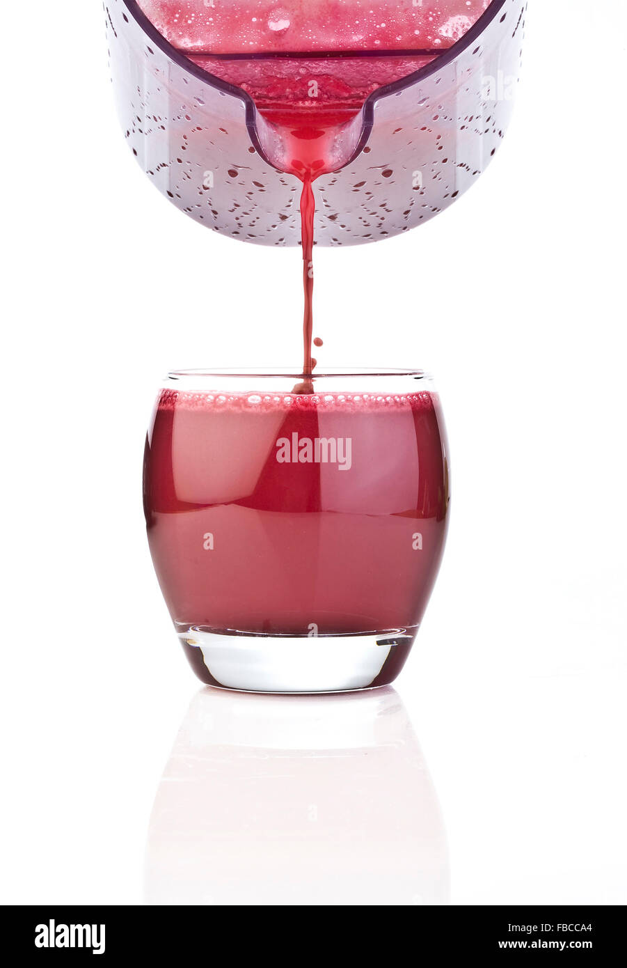 Fresh Red fruit juice poured from jug on a white background Stock Photo