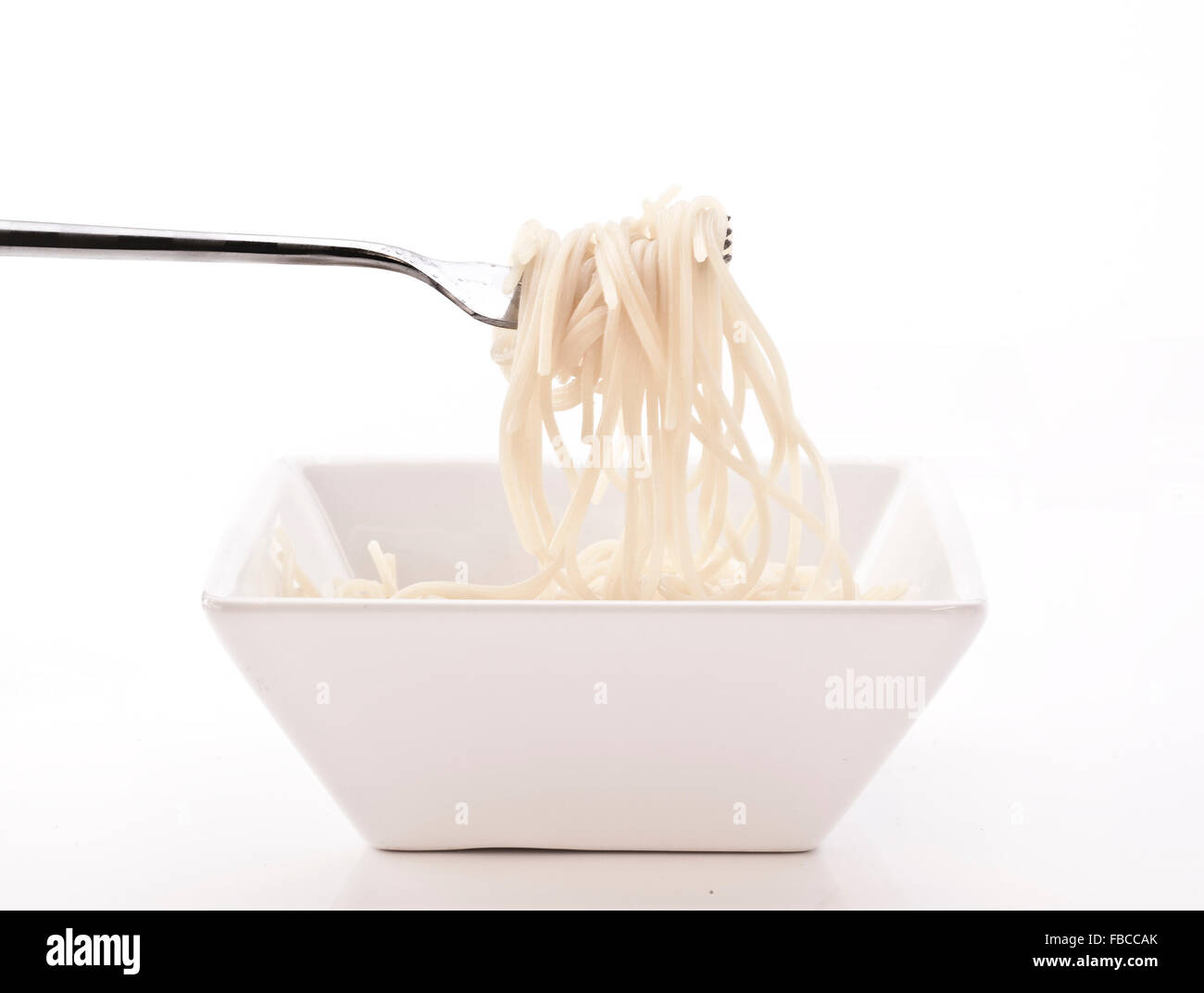 Spaghetti on a fork with white bowl and background Stock Photo