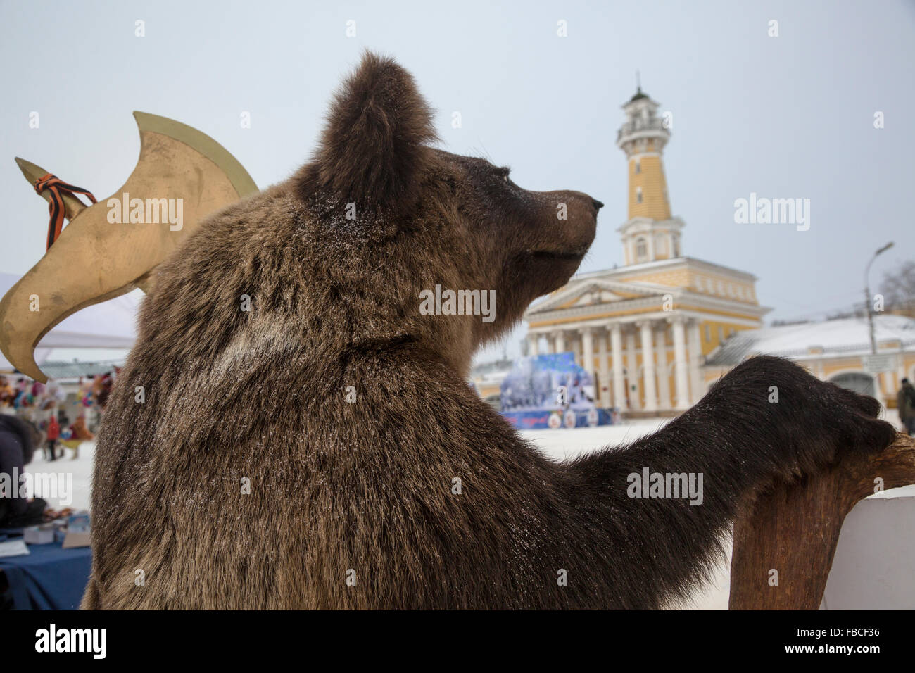 Stuffed bear with a wooden ax stands on the central Susanin square in Kostroma town, Russia Stock Photo