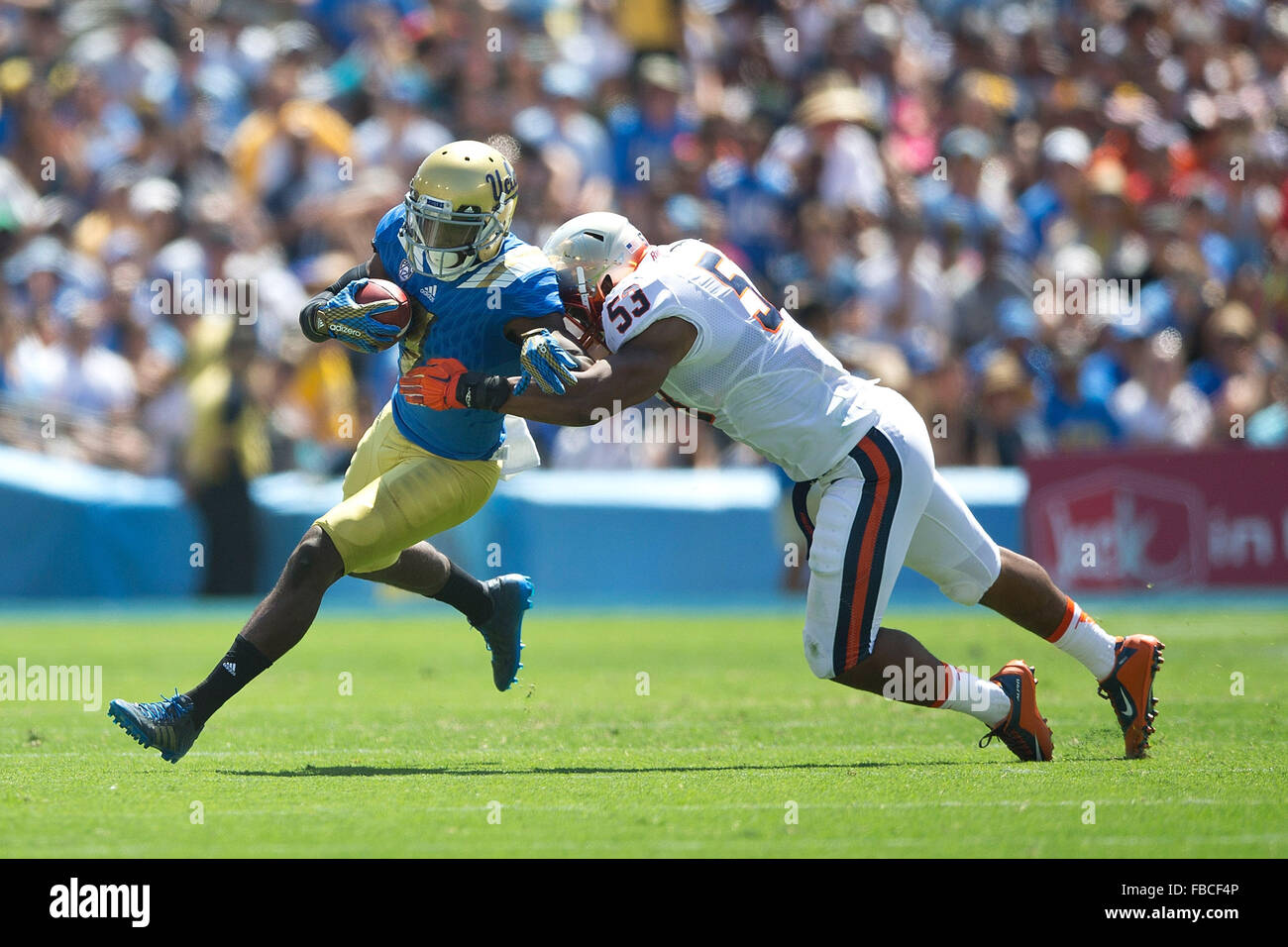 Wide receiver Devin Fuller #7 of the UCLA Bruins is tackled by linebacker Micah Kiser #53 of the Virginia Cavaliers during the Stock Photo