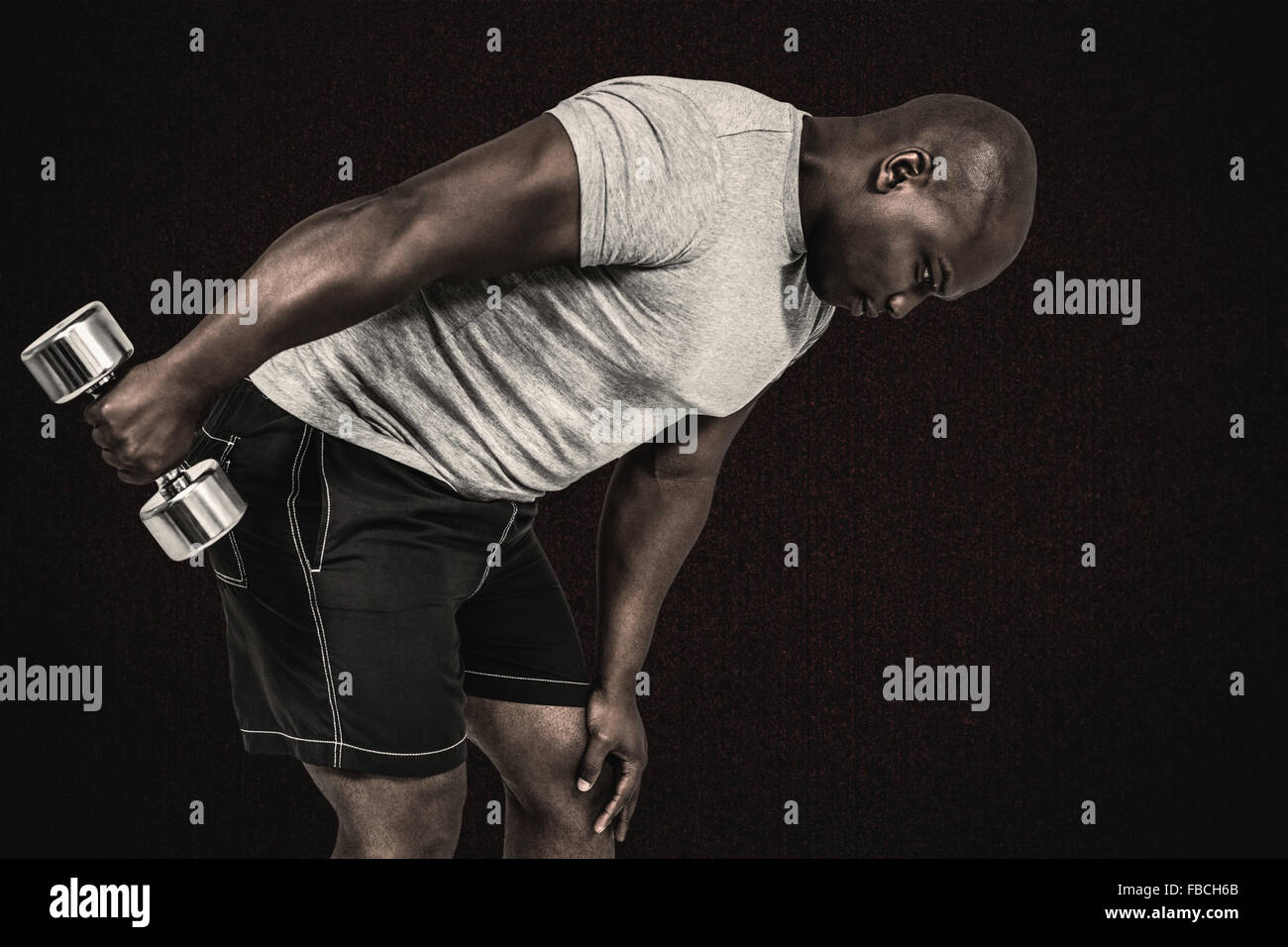 Composite image of fit man exercising with dumbbell Stock Photo