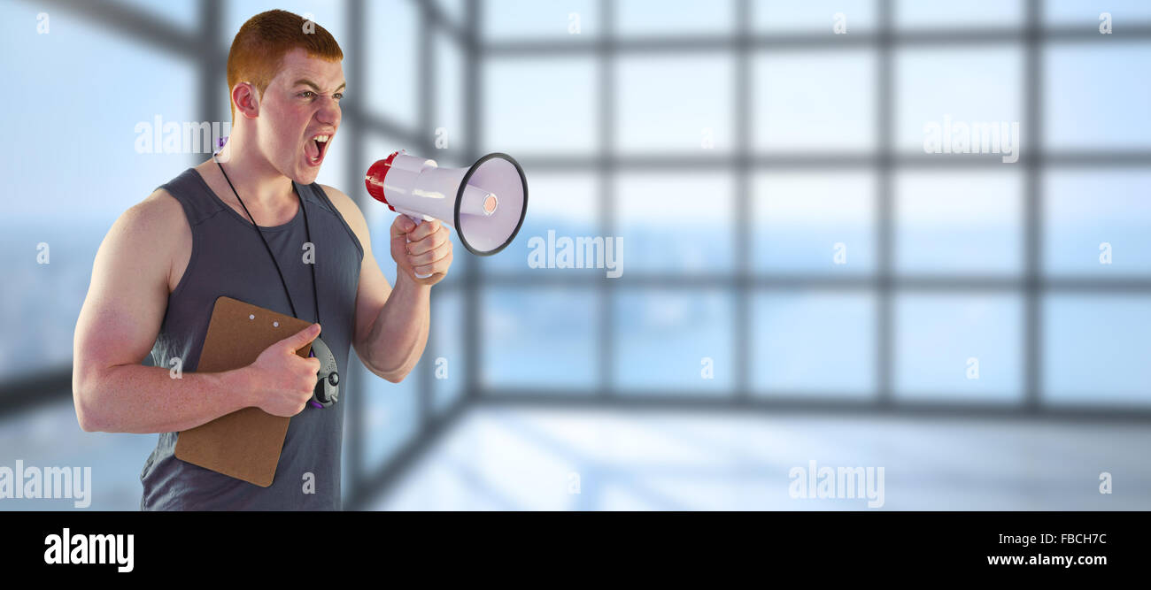 Composite image of angry personal trainer yelling through megaphone Stock Photo