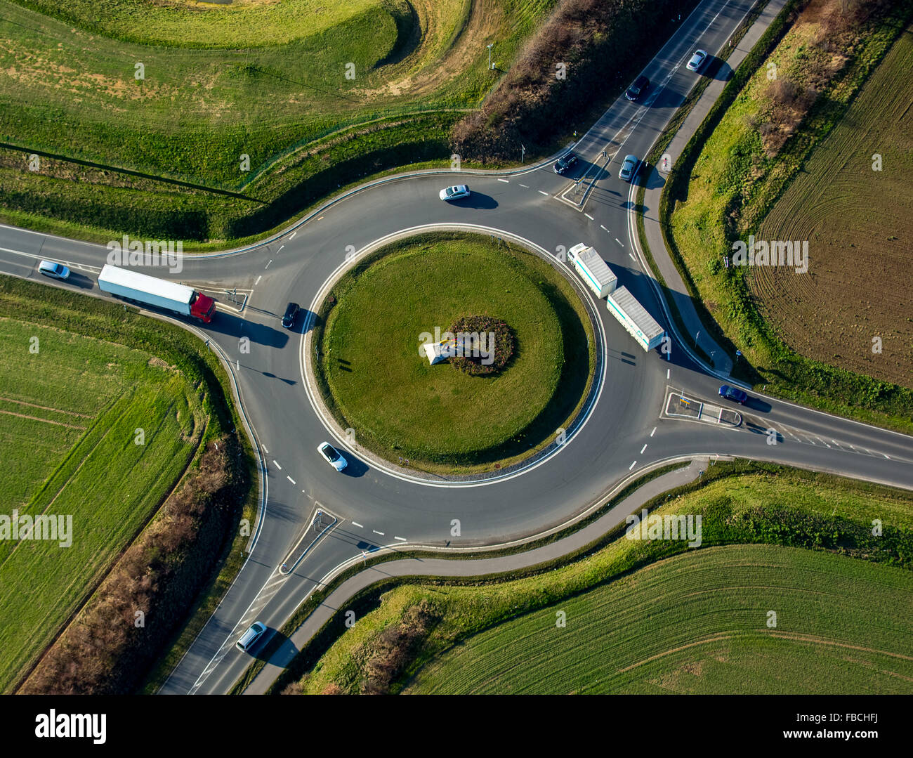Aerial view, roundabout with four exits, truck, green center, lion sculpture in the middle
