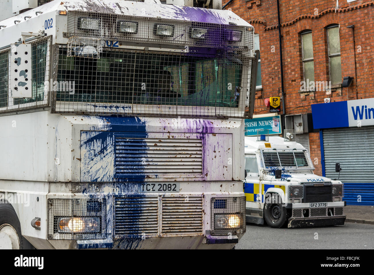 PSNI water cannon vehicle attacked by Irish Republican rioters with paint bombs in Belfast. Stock Photo