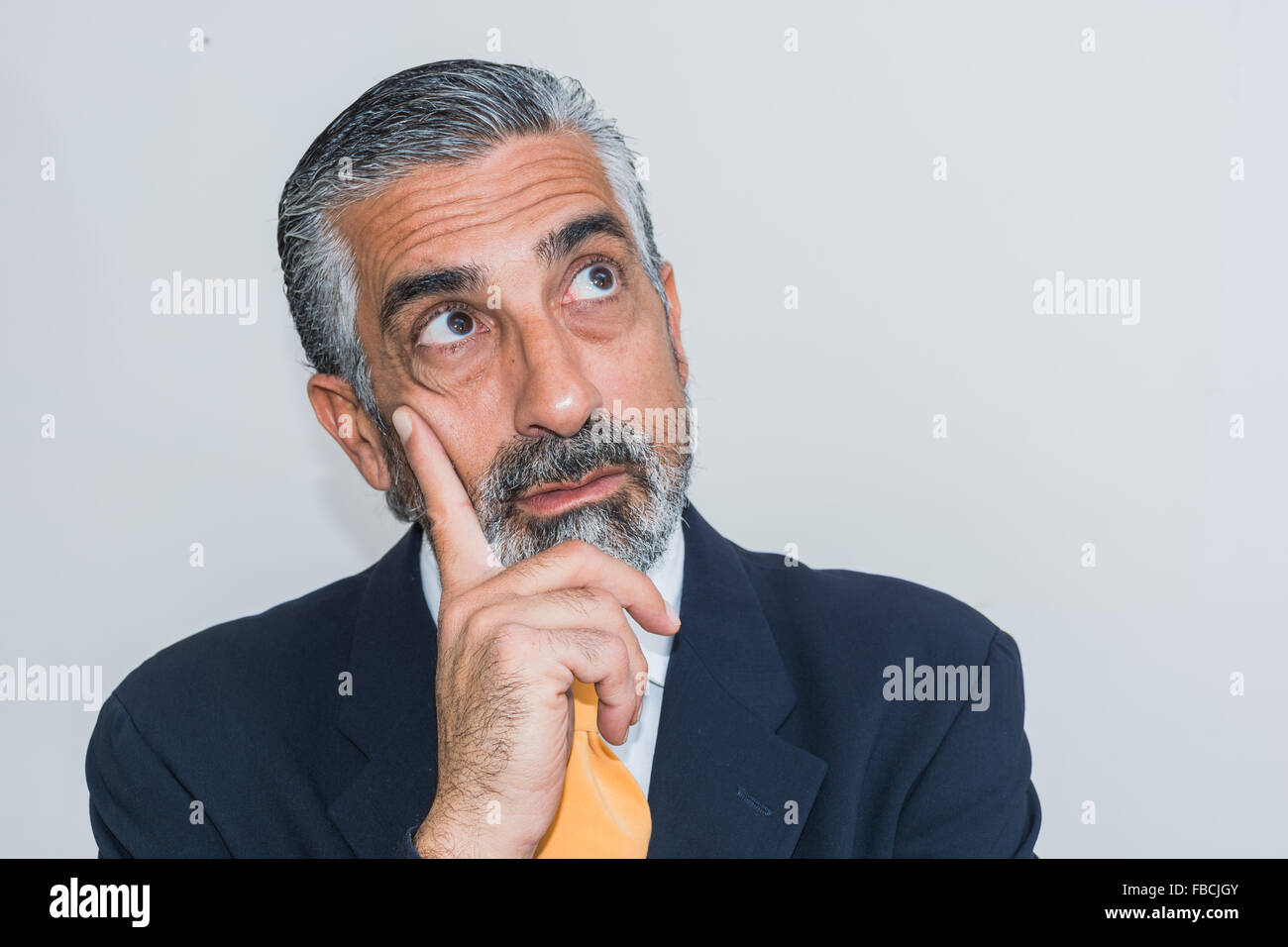 Adult man, mature, in suits. Bearded, grizzled, he thinks, deep in thought. Facial expressions, making faces. Stock Photo