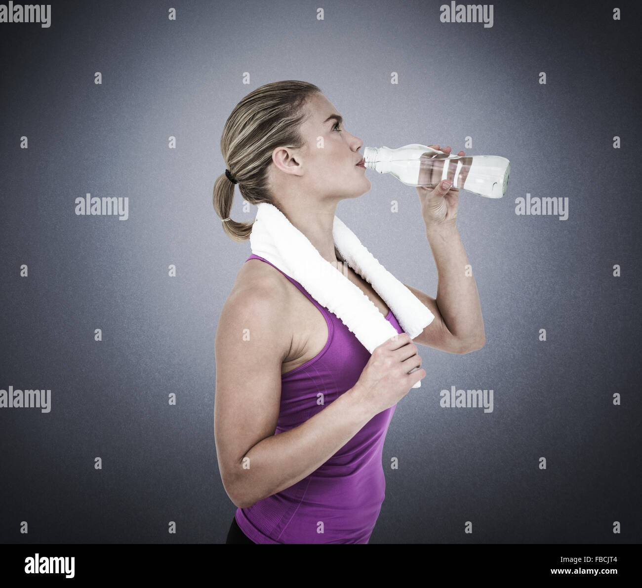 Composite image of muscular woman drinking water Stock Photo