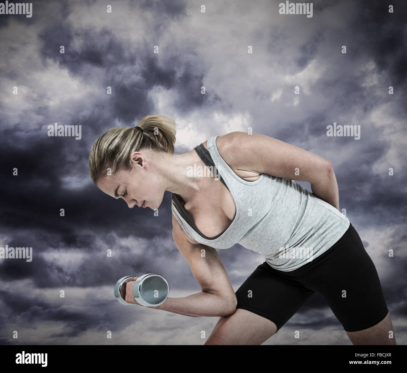 Composite image of  muscular woman working out with dumbbells Stock Photo
