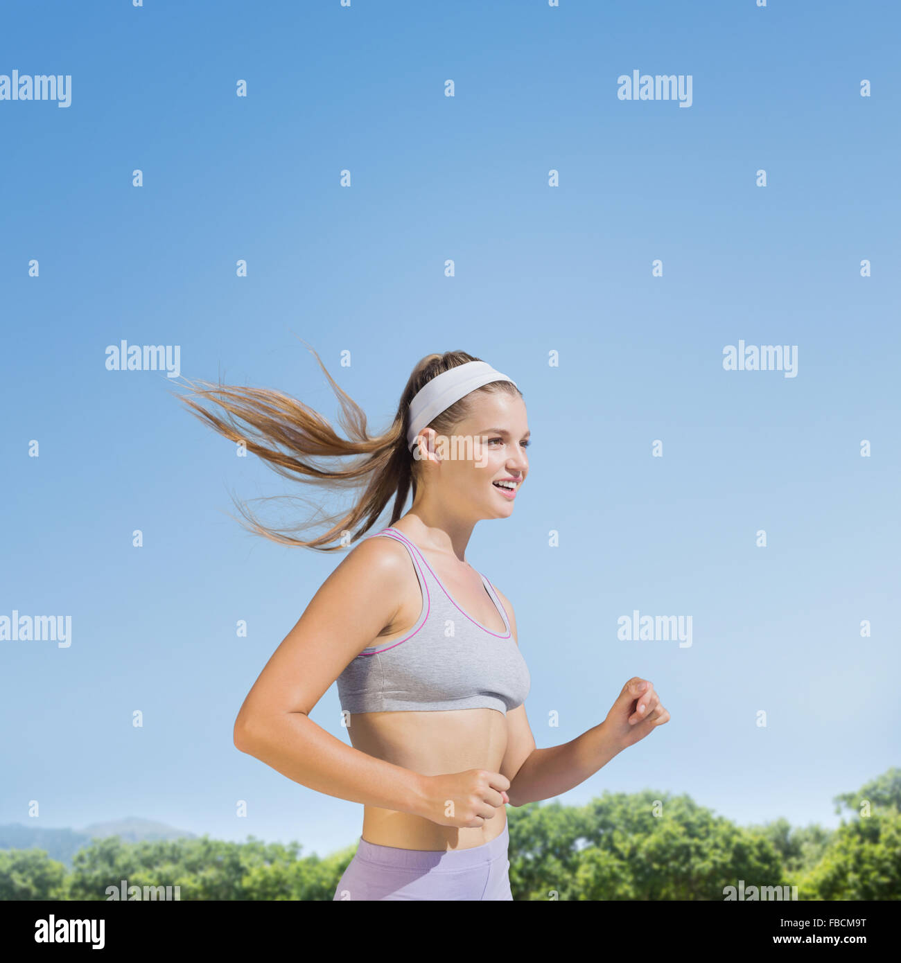 Composite image of sporty smiling blonde jogging Stock Photo